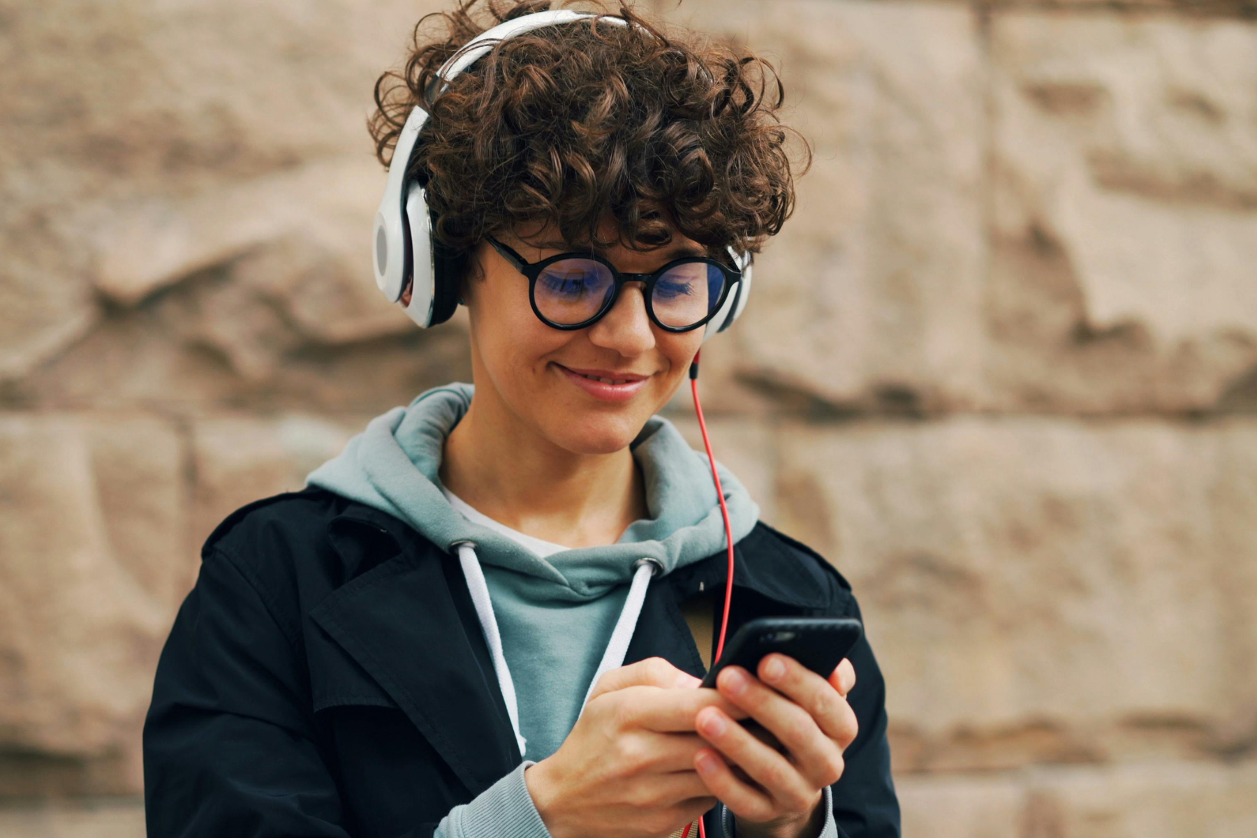 Visitor listening to a guided tour on headphones and phone